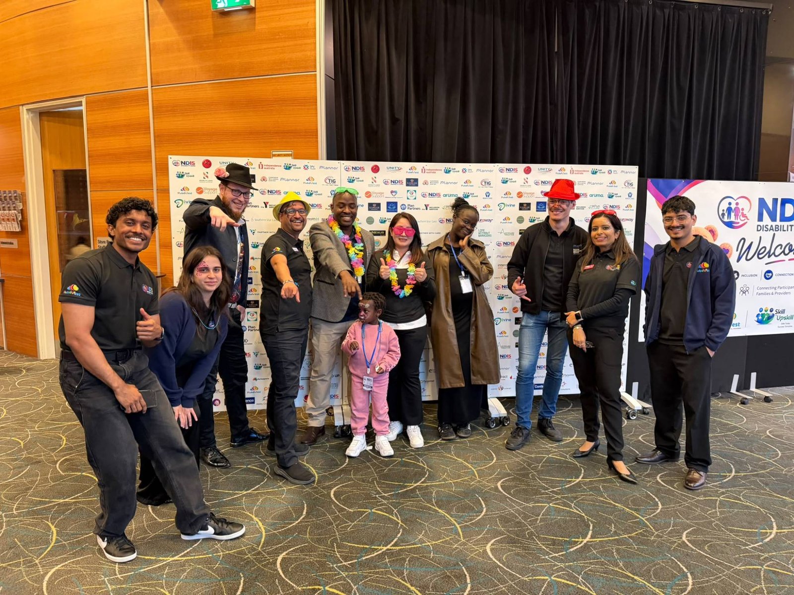 Team and community members posing together at the media wall